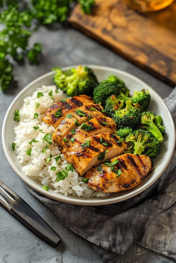 Grilled chicken breast served with fluffy white rice and steamed broccoli—classic high-protein meal prep for fitness and clean eating.