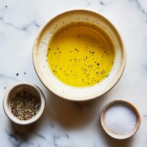 Ingredients being combined to make lemon honey vinaigrette in a glass jar.