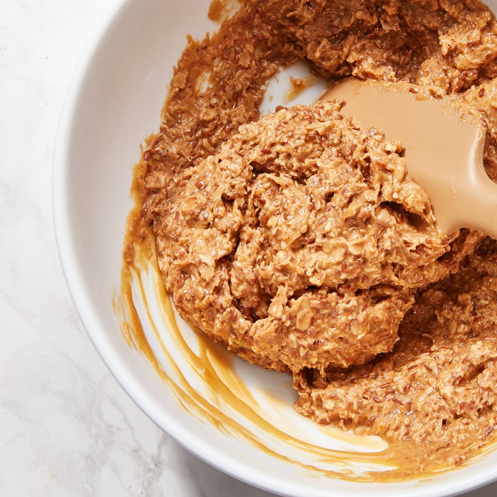 Mixing cashew butter, honey, and oats into a sticky cinnamon dough