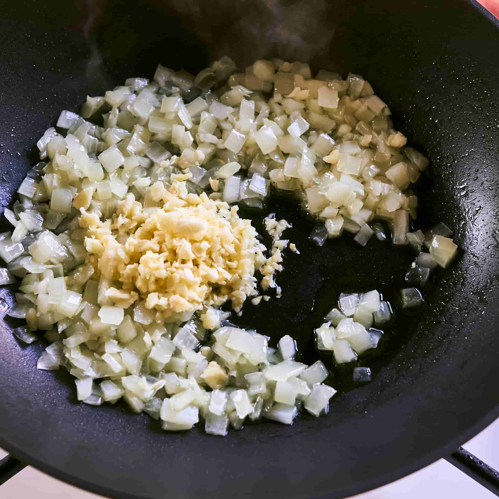 Diced onion and minced garlic cooking in olive oil in a skillet before adding to the crockpot.