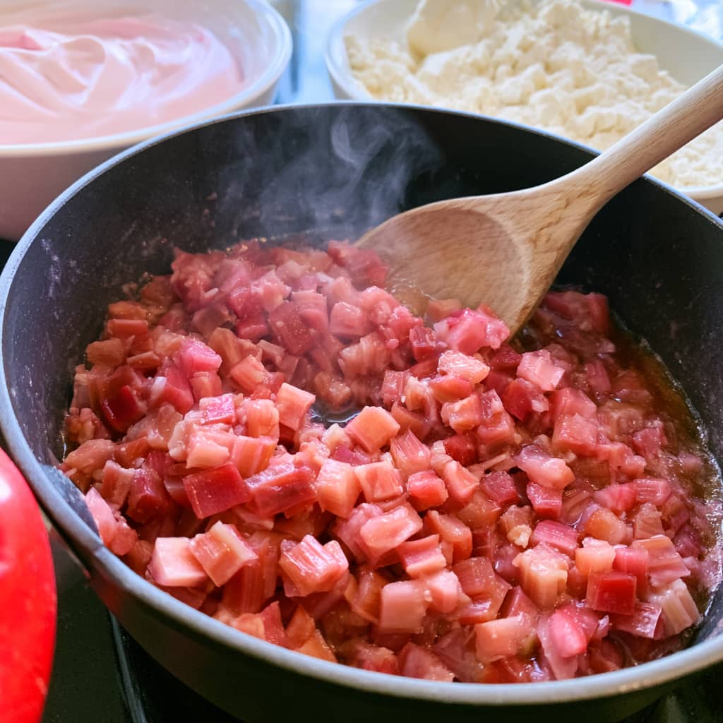 Fresh rhubarb simmering in a saucepan with sweetener for the protein pie filling.