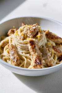Creamy pasta with chicken served in a bowl with a smooth sauce and light garnish