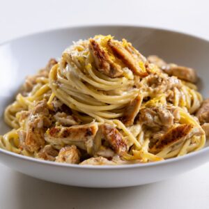 Creamy pasta with chicken served in a bowl with a smooth sauce and light garnish
